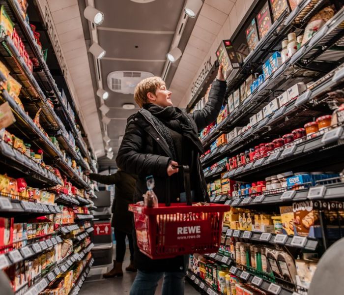 Beim Einkauf im REWE-Einkaufs-Bus trifft man auf eine Kundin. (Foto: REWE)