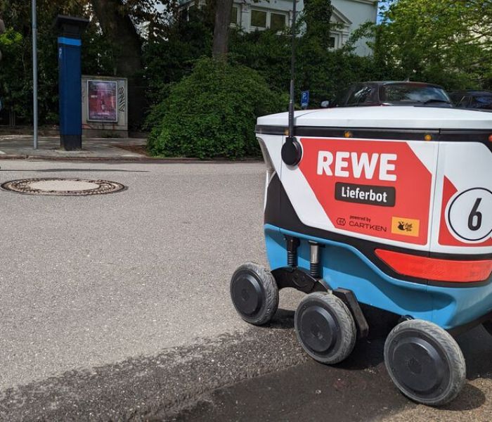 REWE nutzt zur Last-Mile-Logistik ein KI-gesteuertes Lieferbot, das die bestellten Waren an die Haustür der Kunden liefert. (Foto: REWE.)